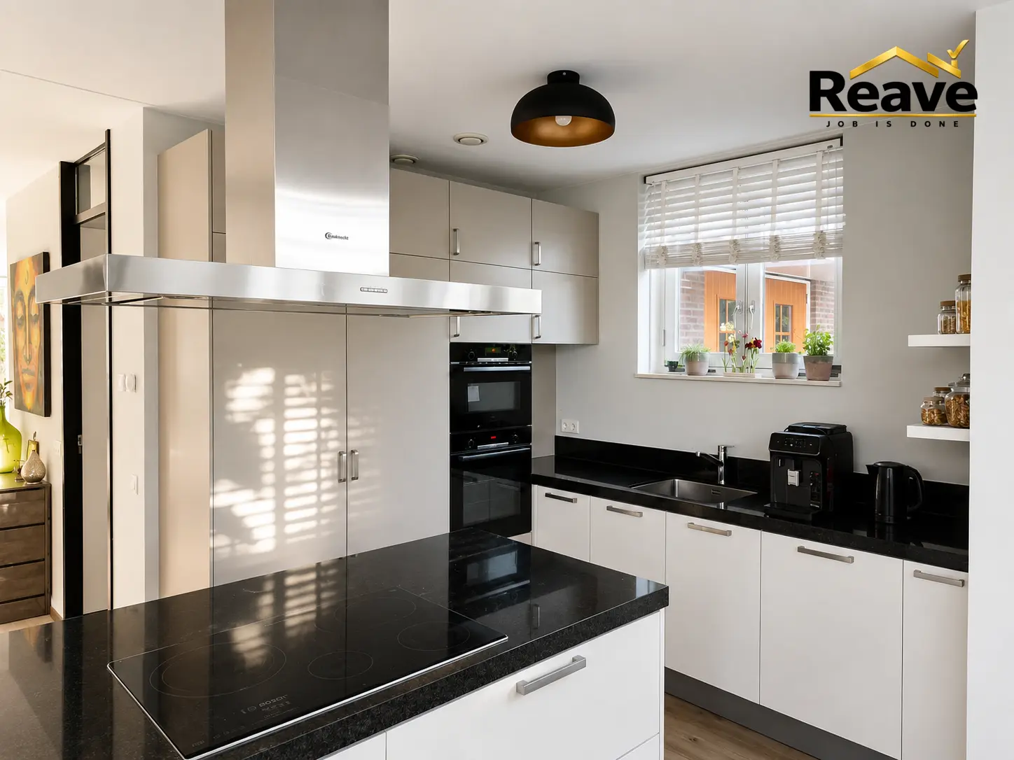 Handleless white kitchen with black granite island and island extractor