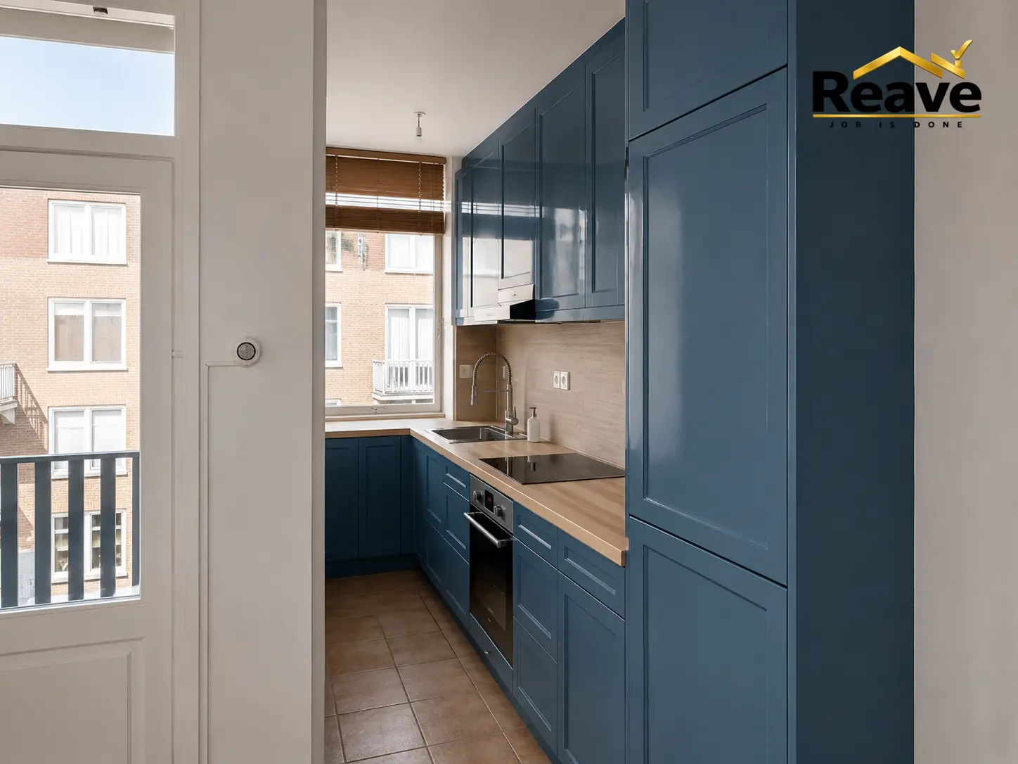 Petrol blue shaker galley kitchen with oak worktop and tall larder units