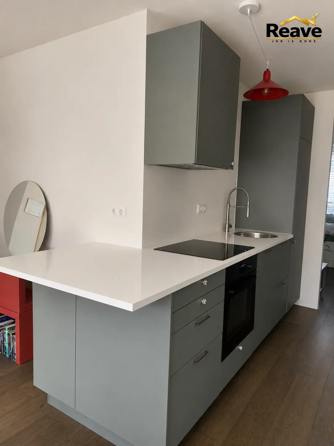 Grey kitchen with white worktop peninsula and red pendant lamp