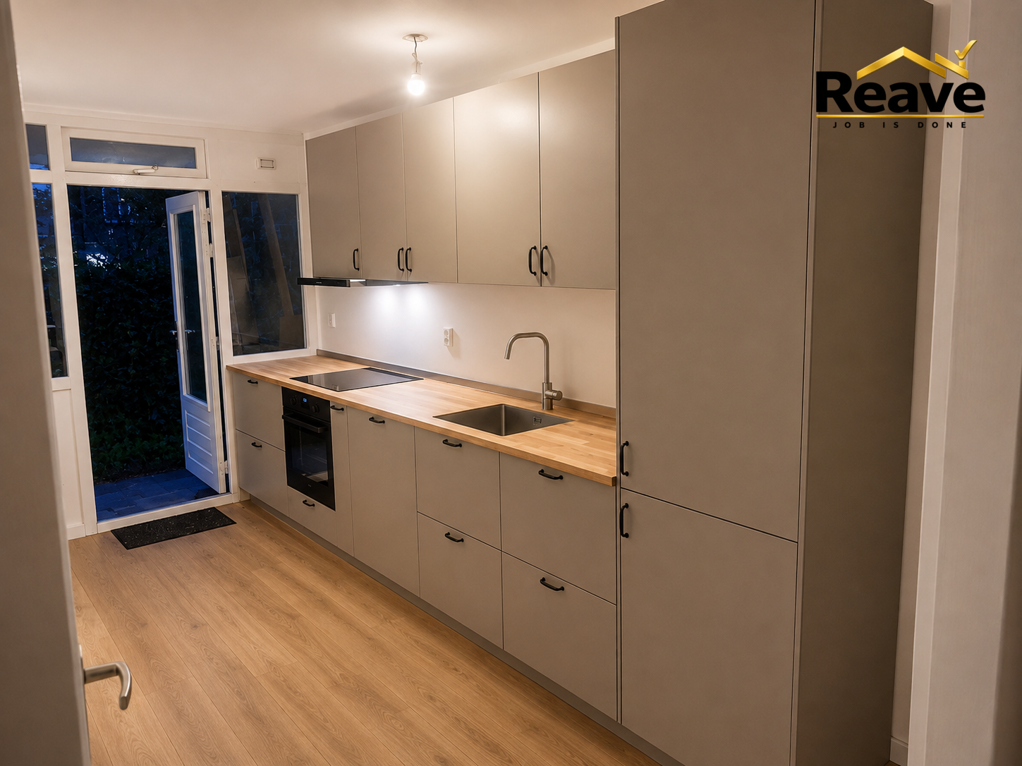 Taupe handleless galley kitchen with solid oak worktop and garden door