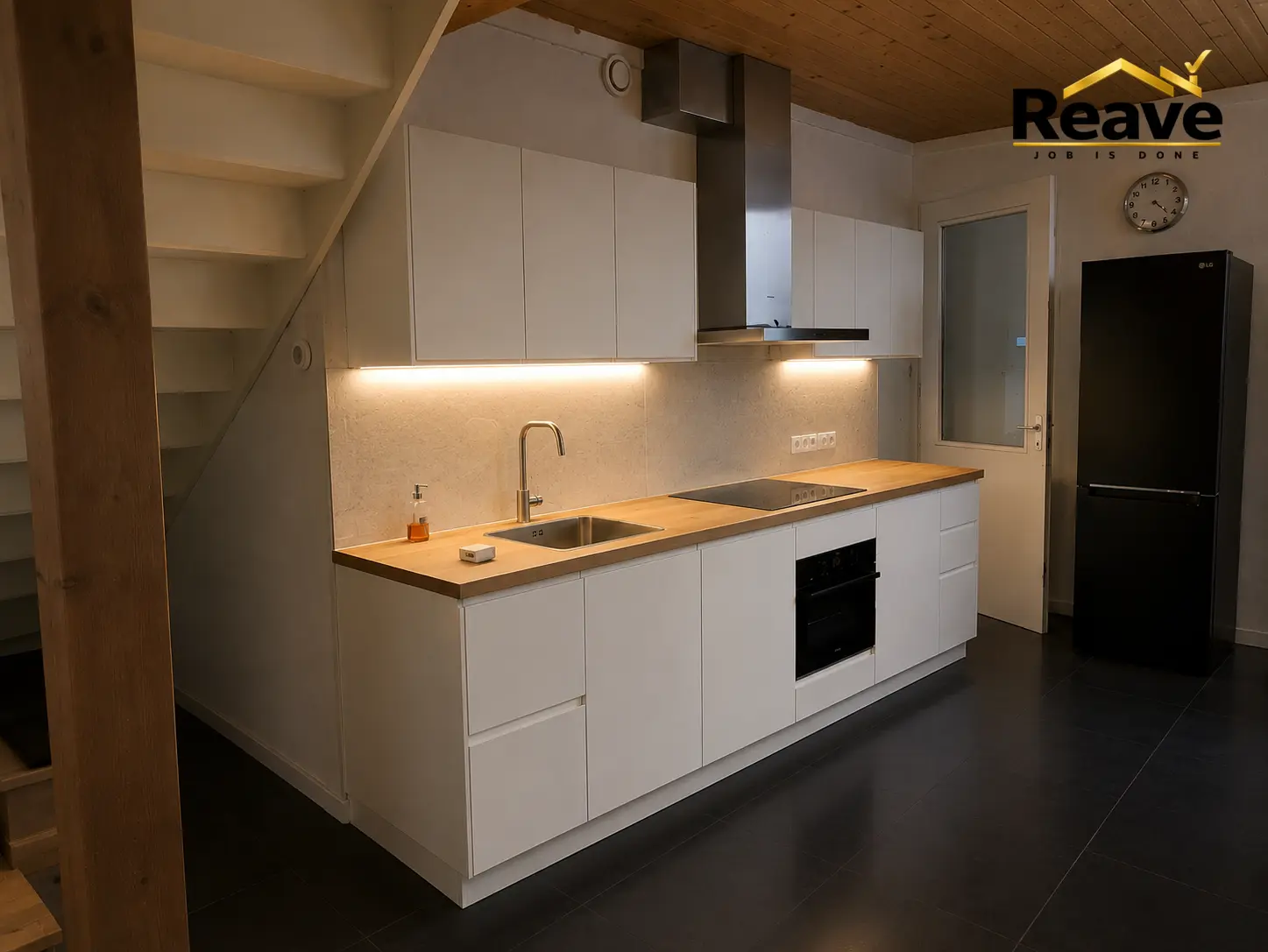 White kitchen with solid oak worktop fitted under a staircase