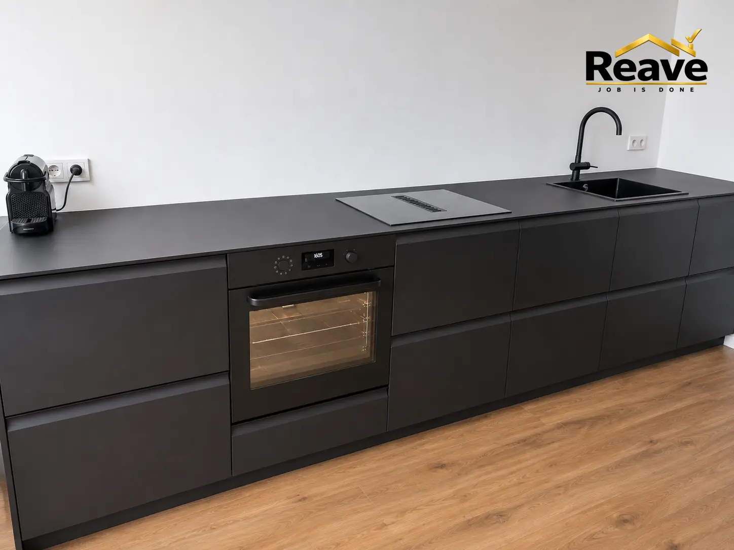 Matte black handleless kitchen run with integrated hob and black sink