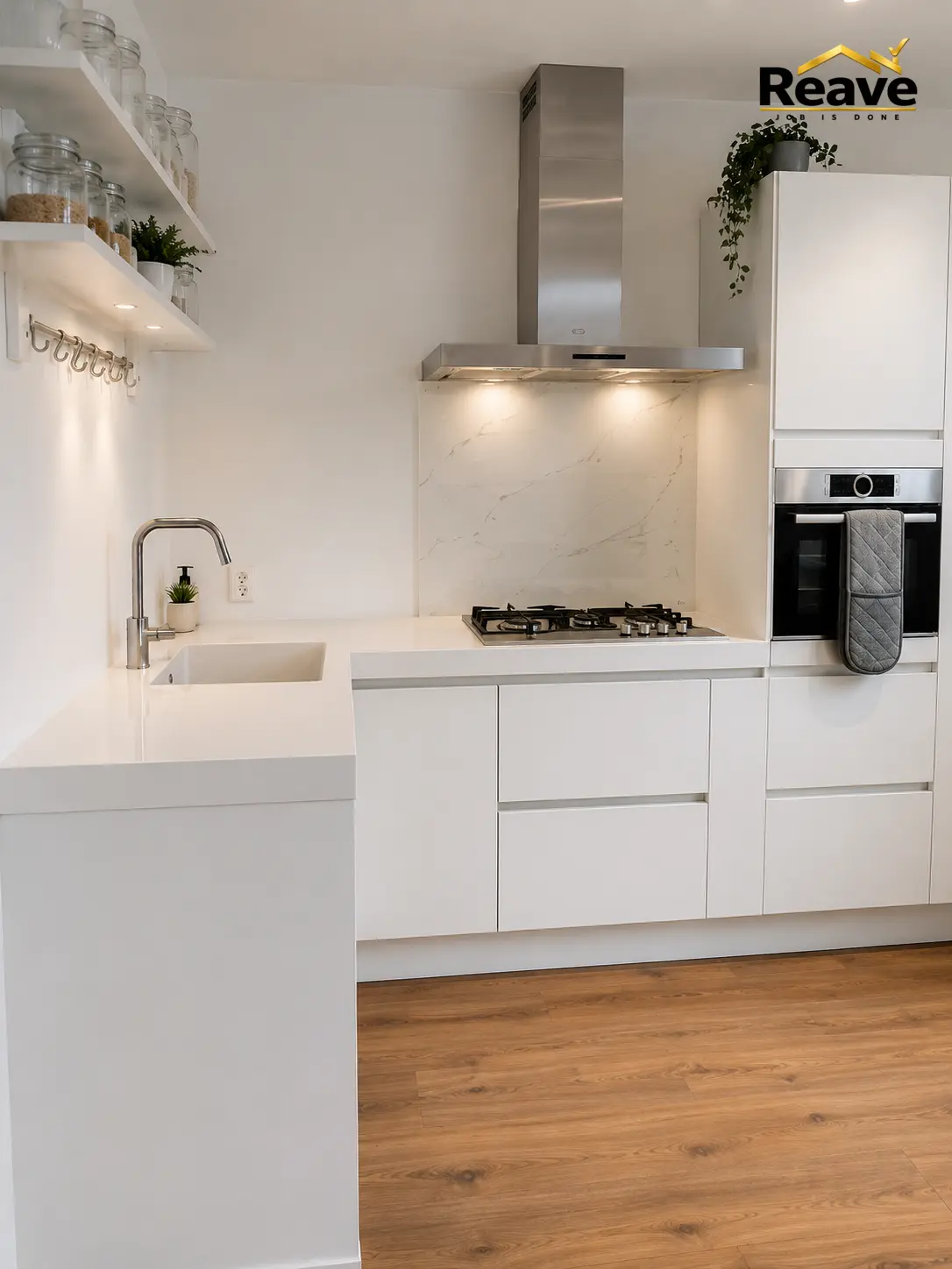 Minimal white kitchen with marble splashback, stainless extractor and peninsula sink