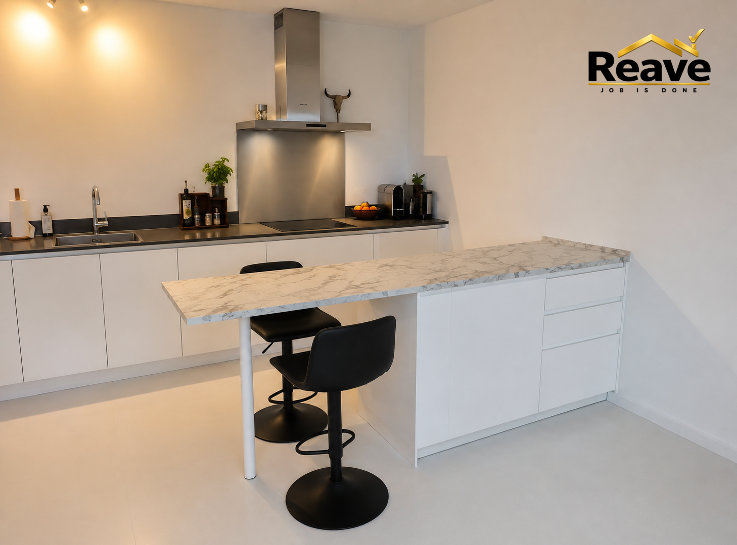 Handleless white kitchen with marble breakfast bar and stainless extractor